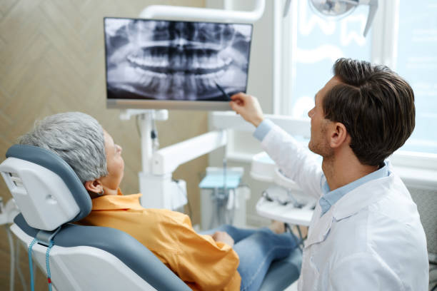 Dentista atendiendo a una paciente en la clínica